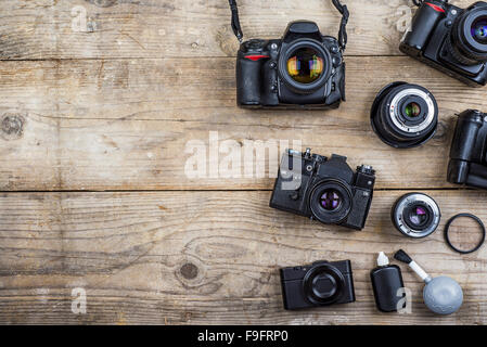 Mix di vecchi telecamere sulla scrivania in legno sfondo. Foto Stock