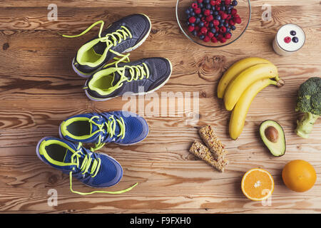 Scarpe da corsa e il cibo sano la composizione su una tavola di legno sfondo Foto Stock