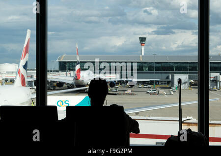 Silhouette di una donna seduta passeggero dalla finestra. travel - aeroporto di Heathrow - Londra - - Gran Bretagna - 28 A Foto Stock