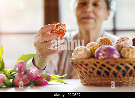 Bella donna senior con uova di pasqua e tulipani. Foto Stock