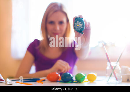 Bella giovane donna pittura a mano le uova di pasqua Foto Stock