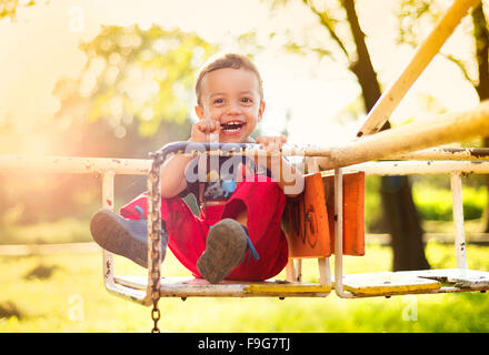 Carino piccolo ragazzo divertirsi sul parco giochi Foto Stock