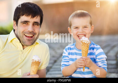 Padre e figlio godendo di gelato al di fuori in un parco Foto Stock