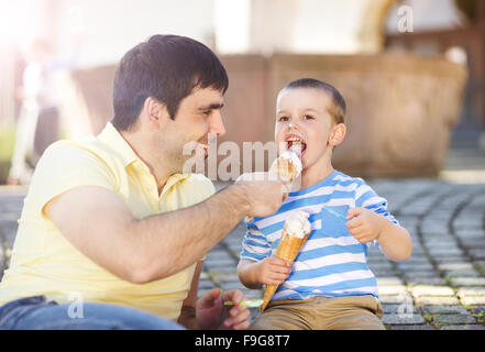 Padre e figlio godendo di gelato al di fuori in un parco Foto Stock