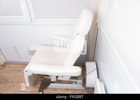 Angolo di Alta Vista di Bianco Spa reclinabile sedia accoccolato in un angolo della stanza bianca in una Spa di lusso Foto Stock