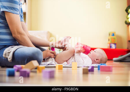 Giovani hipster padre cambiando pannolino per la sua piccola bimba Foto Stock