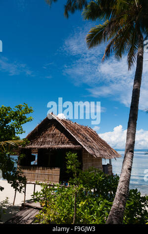 Lonely Nipa Hut su palafitte con Palm tree su una bellissima spiaggia di fronte al mare Foto Stock