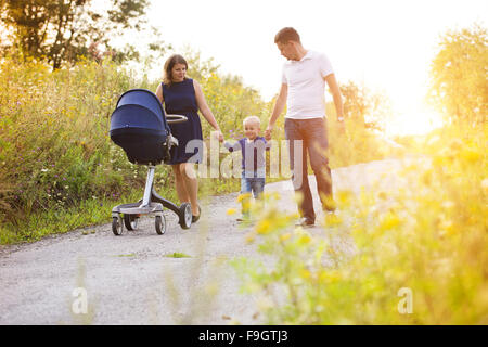 La famiglia felice in una passeggiata nella natura godendo la vita insieme. Foto Stock