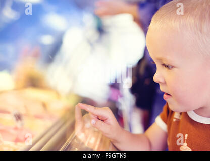 Little Boy godendo il gelato in cafe Foto Stock