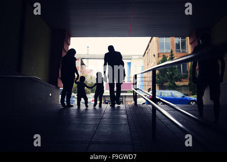 Famiglia giovane con due ragazzini in una stazione della metropolitana Foto Stock