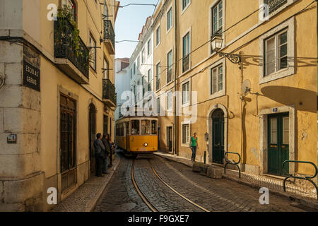 Tram tradizionali, 'Eléctrico', su una stretta strada di Alfama, Lisbona. Foto Stock