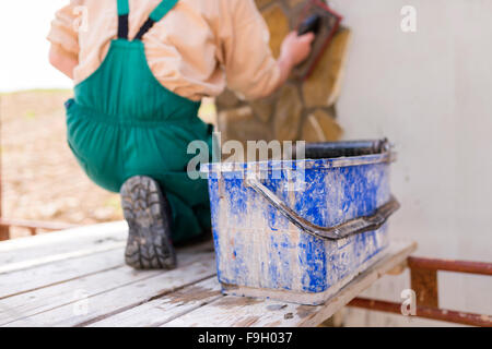 Mason mettendo decorativo pietre naturali su una parete Foto Stock