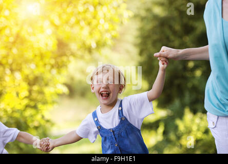 Felice bambina divertendosi con la sua famiglia nel verde della natura. Foto Stock