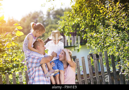 Felice giovane famiglia di trascorrere del tempo insieme al di fuori nel verde della natura. Foto Stock