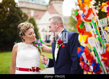 Giovani coppie in viaggio di nozze godendo momenti romantici nella parte anteriore di un castello Foto Stock