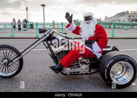 Un uomo vestito da Babbo Natale seduto su una motocicletta sventolare, Brighton, Sussex, Regno Unito Foto Stock