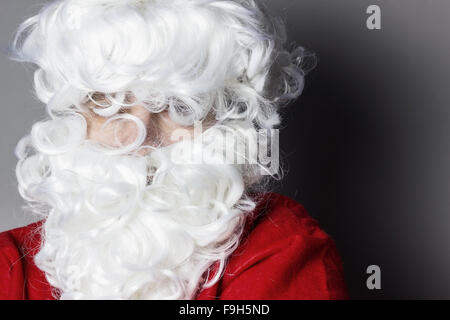 Ritratto di Babbo Natale con tousled i capelli e la barba davanti a uno sfondo grigio Foto Stock