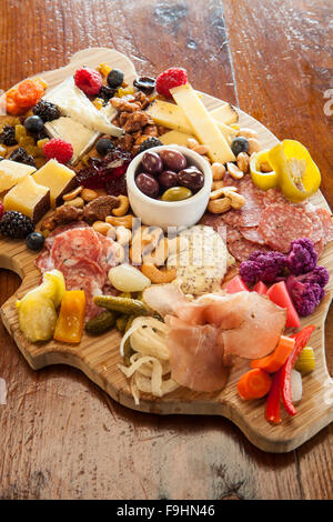 Il maiale a forma di scheda di salumi con formaggi, salumi, verdure sottaceto, marmellate, noci, frutta, olive e crostini, succulenti Cafe Foto Stock