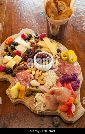 Il maiale a forma di scheda di salumi con formaggi, salumi, verdure sottaceto, marmellate, noci, frutta, olive e crostini, succulenti Cafe Foto Stock