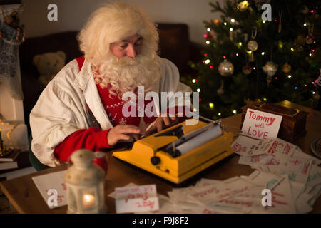 Babbo Natale a casa di rispondere ai bambini le lettere Foto Stock