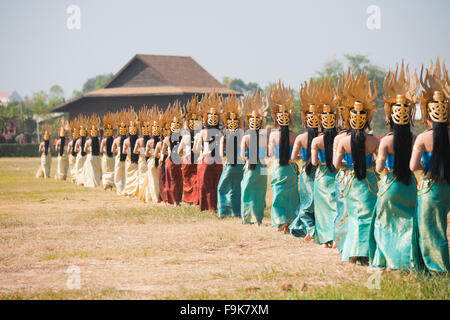 Linea di tradizionalmente condita danzatrici tailandesi camminando sul campo all'annuale di Surin Roundup di elefante Foto Stock