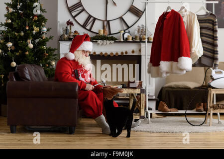 Babbo Natale a casa riparare le sue scarpe, preparazione per il lavoro Foto Stock