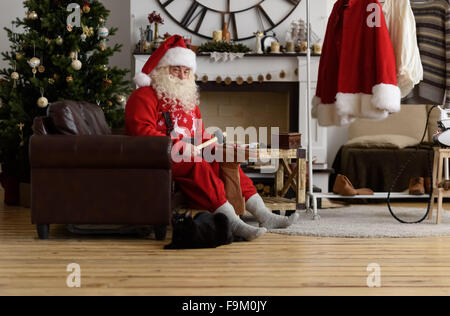 Babbo Natale a casa riparare le sue scarpe, preparazione per il lavoro Foto Stock