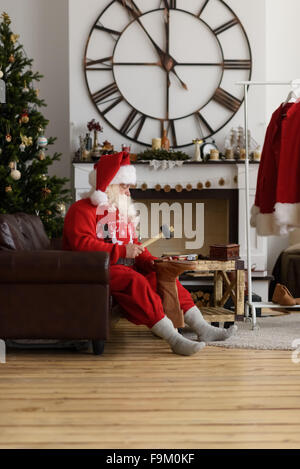 Babbo Natale a casa riparare le sue scarpe, preparazione per il lavoro Foto Stock