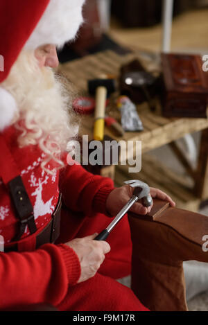 Babbo Natale a casa riparare le sue scarpe, preparazione per il lavoro Foto Stock