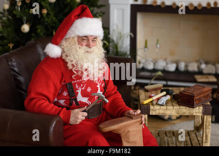 Babbo Natale a casa riparare le sue scarpe, preparazione per il lavoro Foto Stock