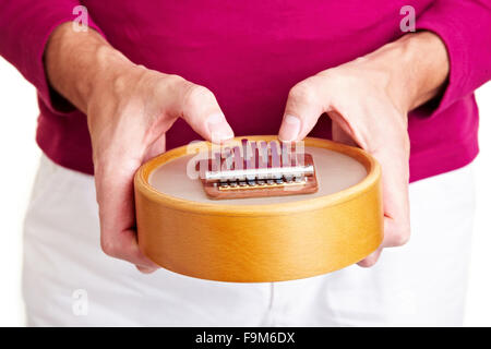 L uomo si gioca su una versione dello strumento africano Kalimba Foto Stock