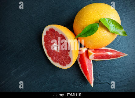 Succo di pompelmo fresco sulla pietra nera Foto Stock