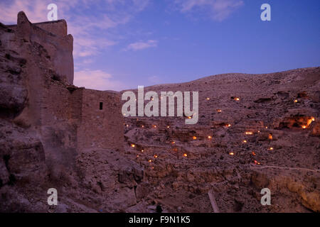 Spia candele che illuminano le piccole grotte vicino Mar Saba monastero nel Judaean o deserto della Giudea durante il Mar Saba giorno il 17 dicembre 2015. I Greci Ortodossi monastero di Santo Lavra di San Sabbas i santificati conosciuto in arabo come Mar Saba fu costruito nel V secolo d.c. ed è stato occupato quasi ininterrottamente da quando è stata fondata, che lo rende uno dei più antichi monasteri abitato nel mondo. Foto Stock