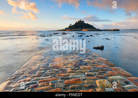 La marea sfuggente rivela una vista del lastricato della strada rialzata che collega St Michael's Mount con la terraferma Foto Stock