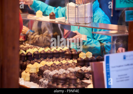 Ritagliato colpo di ricoperta di cioccolato snowballs marshmallow con il consumatore a pagare il contatore in background al mercatino di Natale di Nottingham, UK. Foto Stock