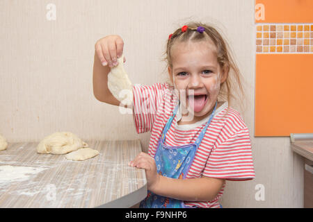 Quattro anni di ragazza prepara torte con il cavolo in cucina Foto Stock