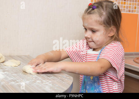 Quattro anni di ragazza prepara torte con il cavolo in cucina Foto Stock