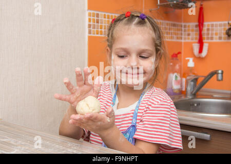 Quattro anni di ragazza prepara torte con il cavolo in cucina Foto Stock