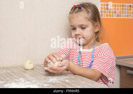 Quattro anni di ragazza prepara torte con il cavolo in cucina Foto Stock