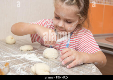 Quattro anni di ragazza prepara torte con il cavolo in cucina Foto Stock