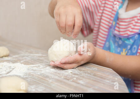 Quattro anni di ragazza prepara torte con il cavolo in cucina Foto Stock