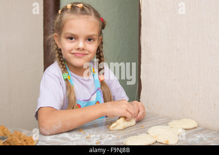 Quattro anni di ragazza prepara torte con il cavolo in cucina Foto Stock