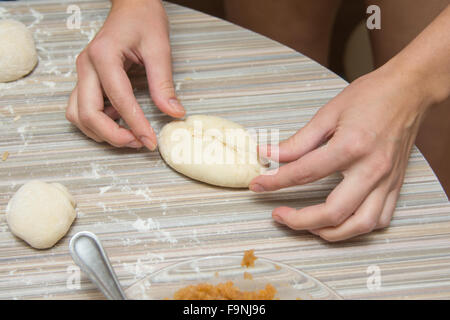 Mani femminili closeup patty stampato con cavolo sul tavolo della cucina Foto Stock