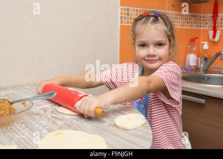 Quattro anni di ragazza prepara torte con il cavolo in cucina Foto Stock