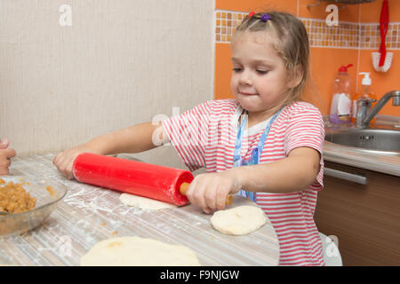 Quattro anni di ragazza prepara torte con il cavolo in cucina Foto Stock