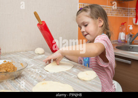 Quattro anni di ragazza prepara torte con il cavolo in cucina Foto Stock