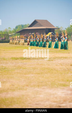 Tailandese tradizionale ballerino esegue in costume tra le fila di belle donne in abiti colorati a Surin annuale Roundup di elefante Foto Stock