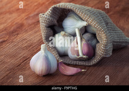 Garlics organico nel sacchetto su un legno marrone tabella Foto Stock