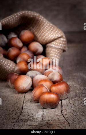 Le nocciole in un sacchetto sul vecchio tavolo in legno Foto Stock