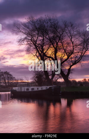 Rufford, Burscough, vicino a Preston, Lancashire, Regno Unito XVIII Dicembre, 2015. Regno Unito Meteo. Continuando clima mite portando un colorato per iniziare la giornata con houseboats residenti presso il St Mary's Marina, sul Leeds Liverpool canal, veglia al cielo viola e una gloriosa sunrise. Credito: Mar fotografico/Alamy Live News Foto Stock